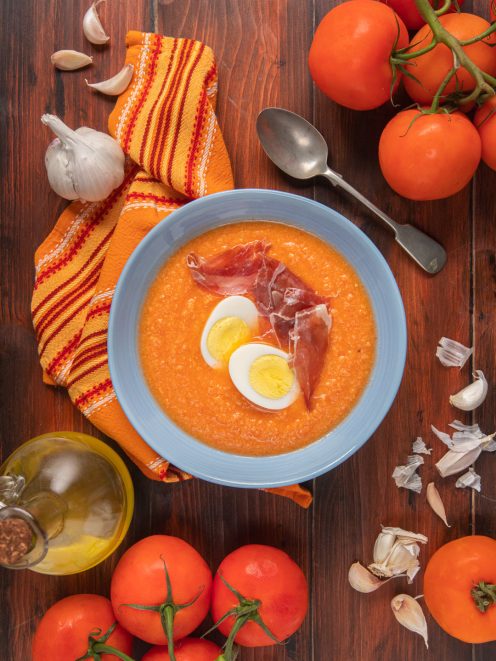 Salmorejo cremoso di pomodoro guarnito con uovo sodo a fette e prosciutto crudo