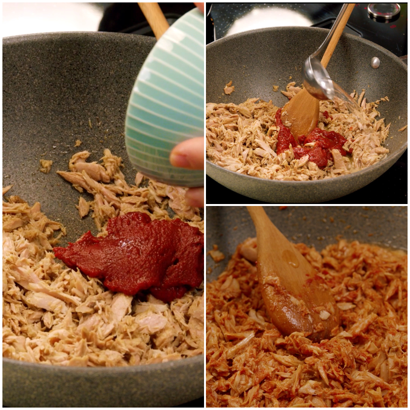 Concentrato di pomodoro versato sul pollo sfilacciato e amalgamato in padella con cucchiaio di legno