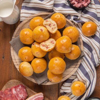 Baci napoletani dorati impilati su alzatina, due spezzati mostrano il ripieno con salumi