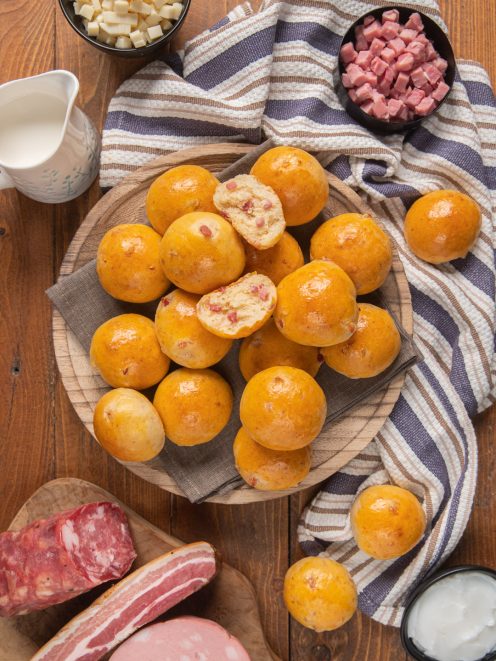 Baci napoletani dorati impilati su alzatina, due spezzati mostrano il ripieno con salumi