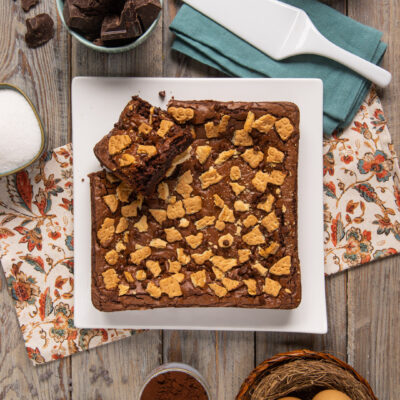 Brownies cioccolato e biscotti tagliati a quadrotti con gocce di cioccolato e biscottini croccanti sopra