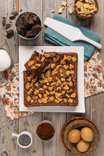 Brownies cioccolato e biscotti tagliati a quadrotti con gocce di cioccolato e biscottini croccanti sopra