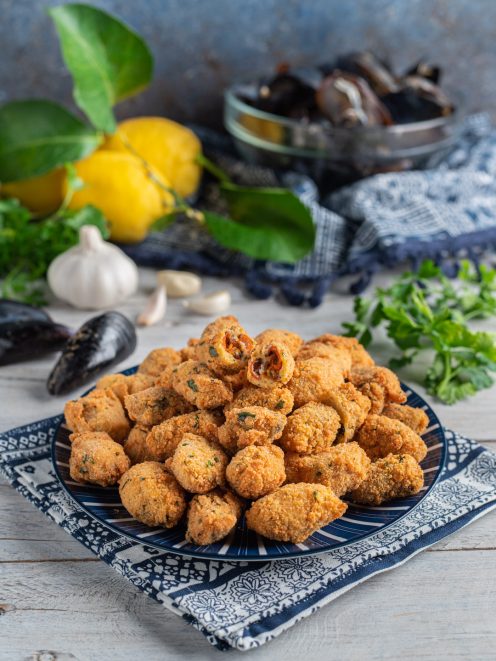 Cozze fritte impanate con prezzemolo, dorate e croccanti, servite in abbondanza