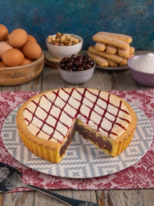 Crostata biscotto all'amarena tagliata, con crema al cioccolato e glassa a rombi di amarena