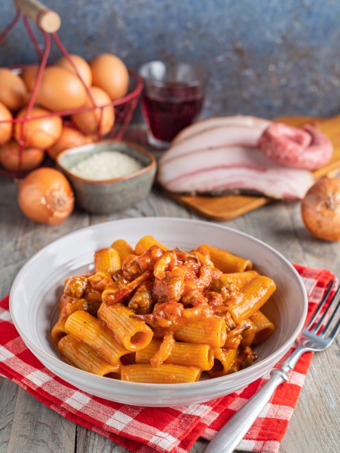 Pasta alla zozzona con rigatoni conditi da un ricco sugo di pomodoro, salsiccia e guanciale