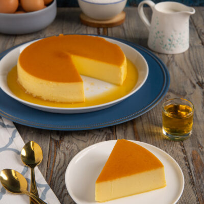 Quesillo intero con una fetta tagliata a parte, superficie dorata di caramello e consistenza morbida in vista