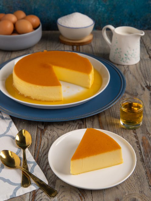 Quesillo intero con una fetta tagliata a parte, superficie dorata di caramello e consistenza morbida in vista