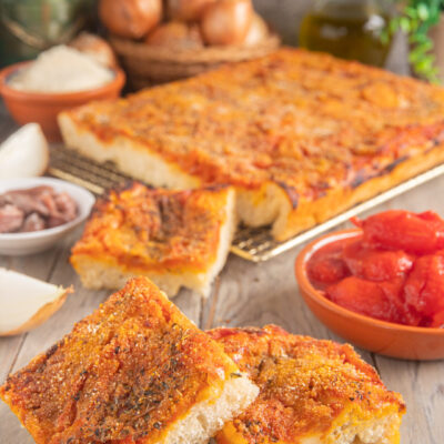 Sfincione palermitano con pomodoro, cipolla e pangrattato, tagliato a fette con la mollica ben visibile