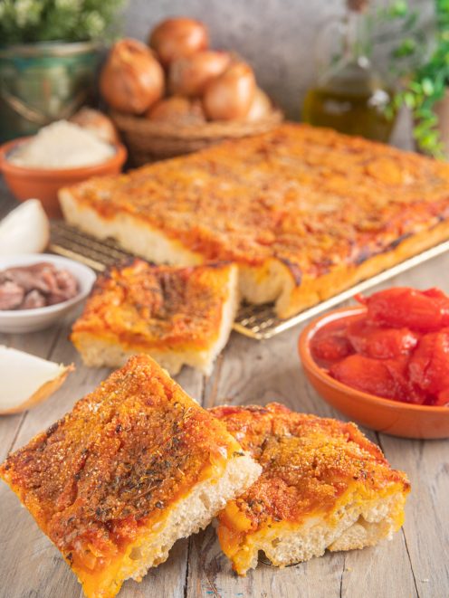 Sfincione palermitano con pomodoro, cipolla e pangrattato, tagliato a fette con la mollica ben visibile