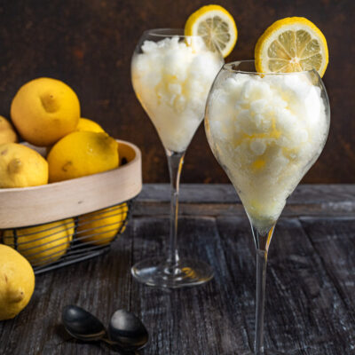 Sorbetto al limone servito in due calici con una fetta di limone sul bordo