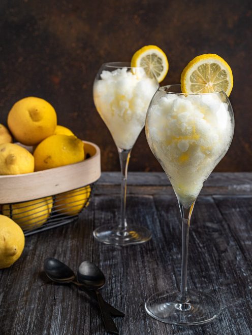 Sorbetto al limone servito in due calici con una fetta di limone sul bordo