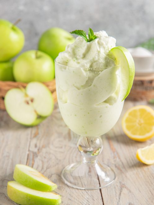 Sorbetto alla mela verde servito in coppa con fetta di mela e foglioline di menta