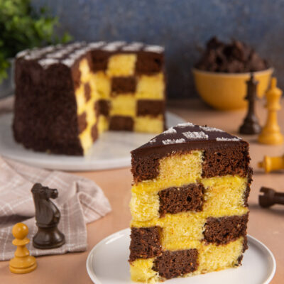 Torta a scacchi con quadretti di pan di spagna al cacao e alla vaniglia ricoperta di glassa al cioccolato