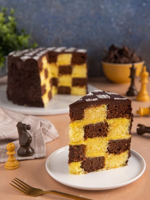 Torta a scacchi con quadretti di pan di spagna al cacao e alla vaniglia ricoperta di glassa al cioccolato