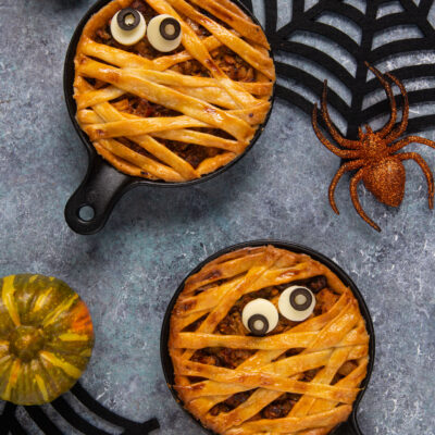 Tortine mummia di Halloween con strisce di pasta intrecciate e occhi di pasta di zucchero in mini padelle