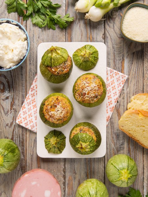 Zucchine tonde ripiene di mortadella gratinate con parmigiano, servite su vassoio