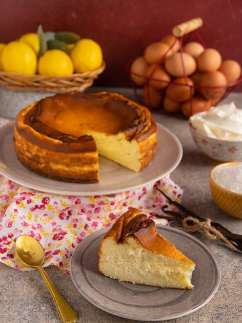 Cheesecake basca con superficie caramellata e fetta tagliata dal cuore cremoso