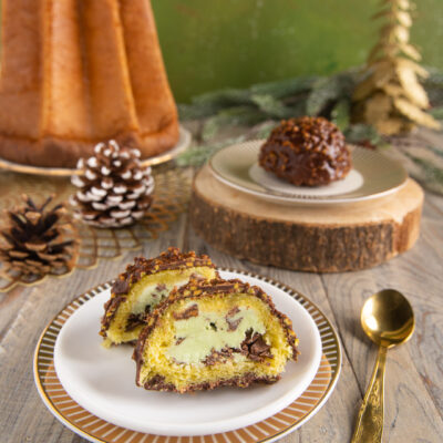 Delizie al pandoro e pistacchio a fette, ricoperte di cioccolato e granella, con crema verde al centro