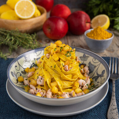 Fettuccine al curry con mele, calamari e pane croccante arrotolate in un nido dorato profumato al prezzemolo
