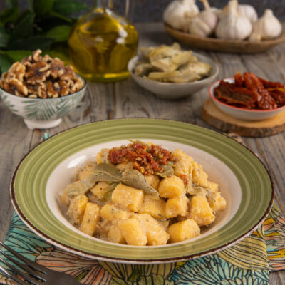Gnocchi di polenta con carciofi trifolati e pomodori secchi a guarnire
