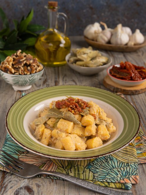 Gnocchi di polenta con carciofi trifolati e pomodori secchi a guarnire