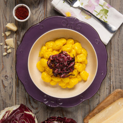 Gnocchi allo zafferano conditi con radicchio rosso saltato e scaglie di parmigiano