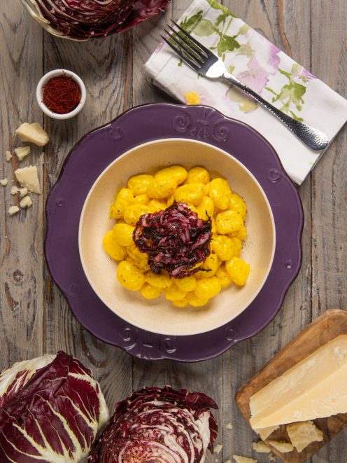 Gnocchi allo zafferano conditi con radicchio rosso saltato e scaglie di parmigiano