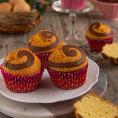 Muffin spirale con pirottini rossi decorati e cuore a chiocciola di cacao e vaniglia