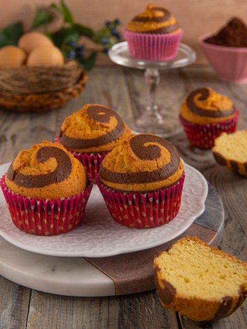 Muffin spirale con pirottini rossi decorati e cuore a chiocciola di cacao e vaniglia