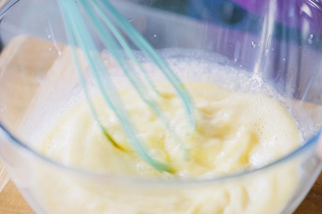 Pastella per pancakes liscia e omogenea mescolata con la frusta in una ciotola