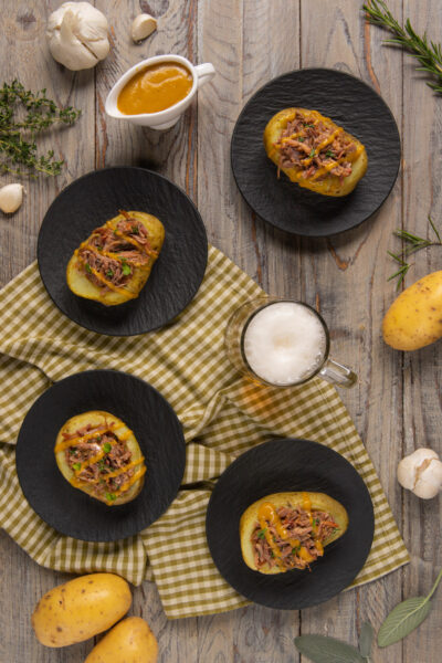 Patate ripiene di stinco sfilacciato con salsa alla birra ed erba cipollina, servite in quattro porzioni