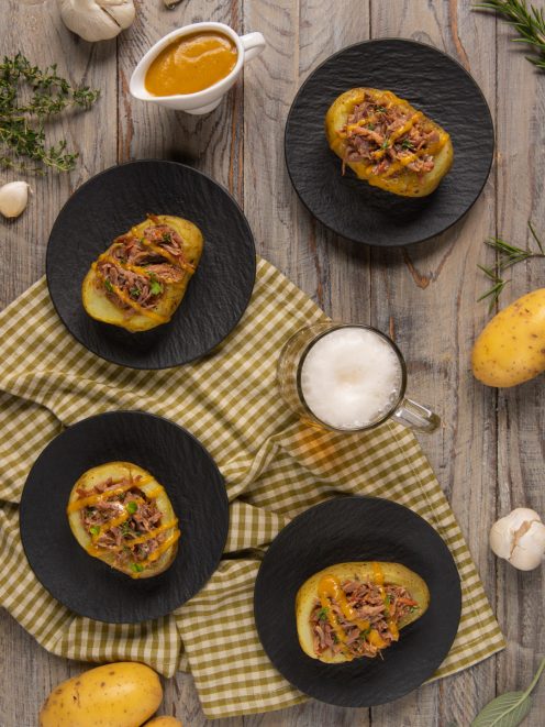Patate ripiene di stinco sfilacciato con salsa alla birra ed erba cipollina, servite in quattro porzioni