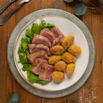 Tagliata di manzo al sangue con patate sabbiate dorate e rucola fresca