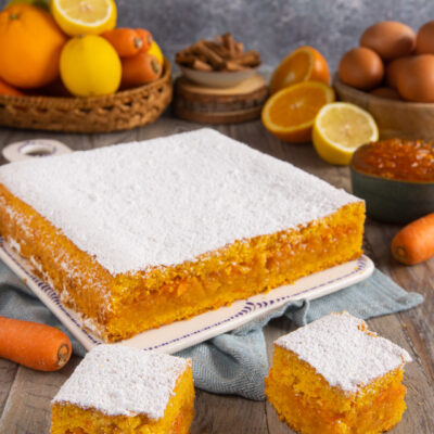 Torta con marmellata di arance, carote e limoni tagliata a quadrotti e spolverata di zucchero a velo