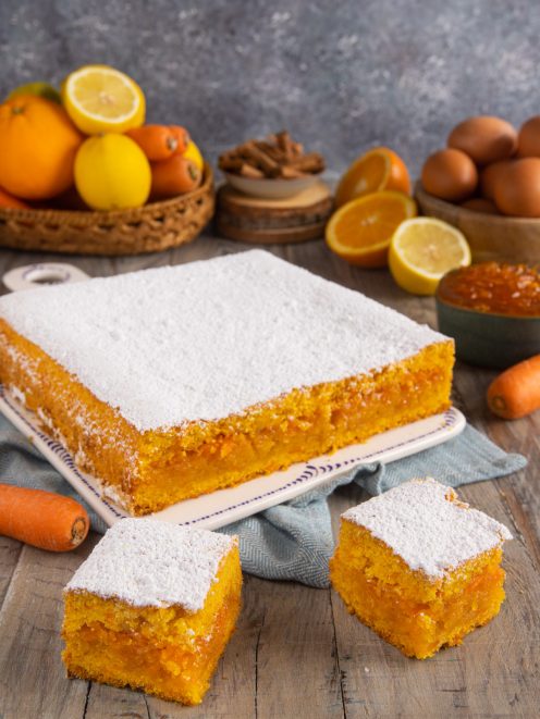Torta con marmellata di arance, carote e limoni tagliata a quadrotti e spolverata di zucchero a velo