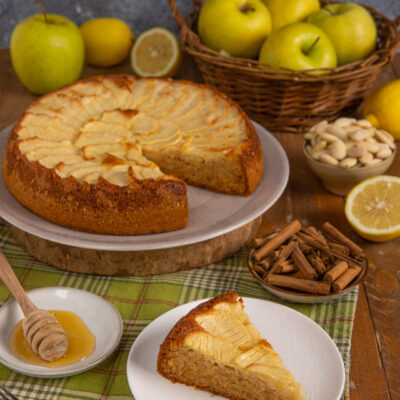 Torta di mele senza glutine con fettine disposte a ventaglio e una fetta servita accanto