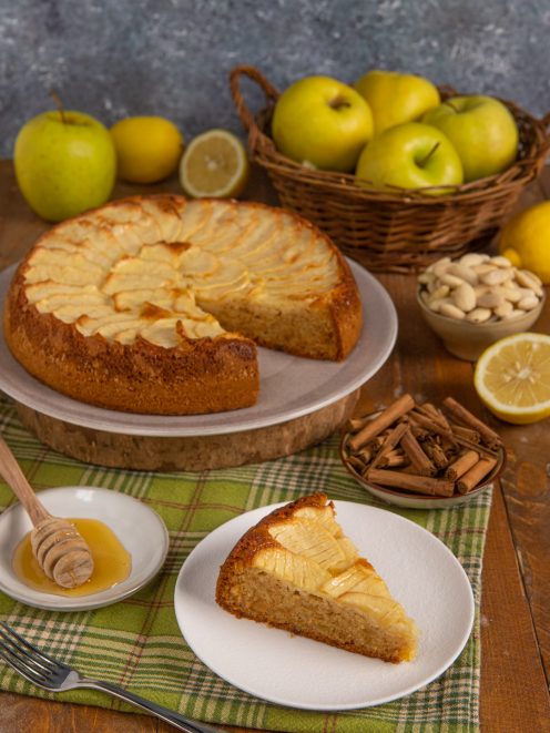 Torta di mele senza glutine con fettine disposte a ventaglio e una fetta servita accanto