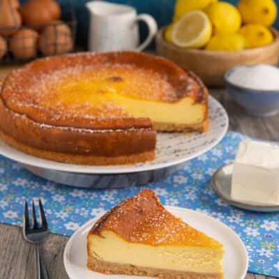 Torta di robiola al limone con una fetta tagliata che mostra il ripieno cremoso e la base friabile
