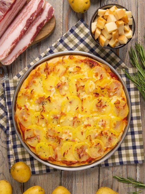 Pizza con patate e pancetta croccante ricoperta di formaggio filante e rosmarino