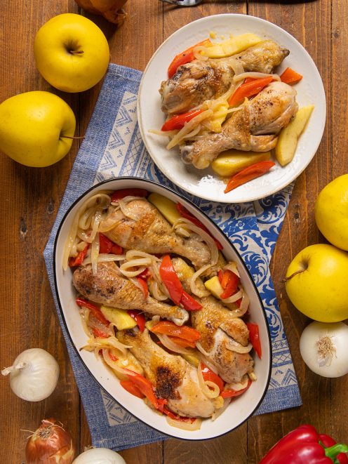 Pollo al sidro con mele, cosce dorate su peperoni e cipolle stufate in pirofila e piatto