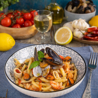 Scialatielli allo scoglio con cozze aperte, vongole, gamberi e calamari, guarniti con basilico fresco