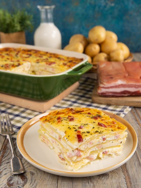 Sformato di patate a strati con pancetta e formaggio filante, servito a fetta
