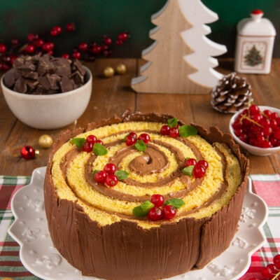 Torta tronco di Natale a spirale con crema al cioccolato, guscio di cioccolato e ribes rosso