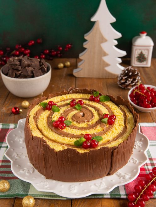 Torta tronco di Natale a spirale con crema al cioccolato, guscio di cioccolato e ribes rosso
