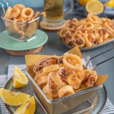 Calamari fritti dorati e croccanti serviti con spicchi di limone fresco