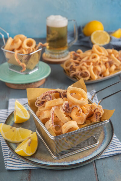 Calamari fritti dorati e croccanti serviti con spicchi di limone fresco