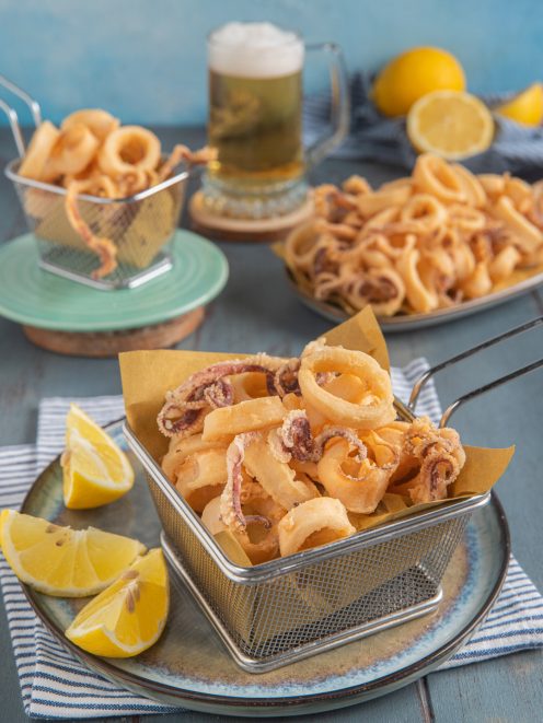 Calamari fritti dorati e croccanti serviti con spicchi di limone fresco