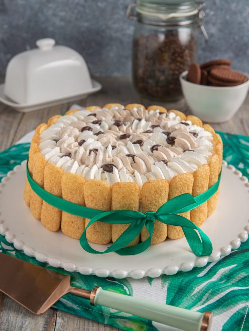 Charlotte al caffè con savoiardi a cornice, ciuffi di panna e gocce di cioccolato in superficie