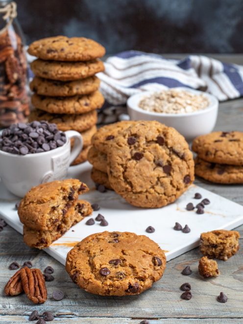 Cookies con gocce di cioccolato e noci pecan, uno spezzato mostra l'interno morbido