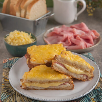 Croque monsieur tagliato a metà con formaggio fuso gratinato e prosciutto cotto a vista